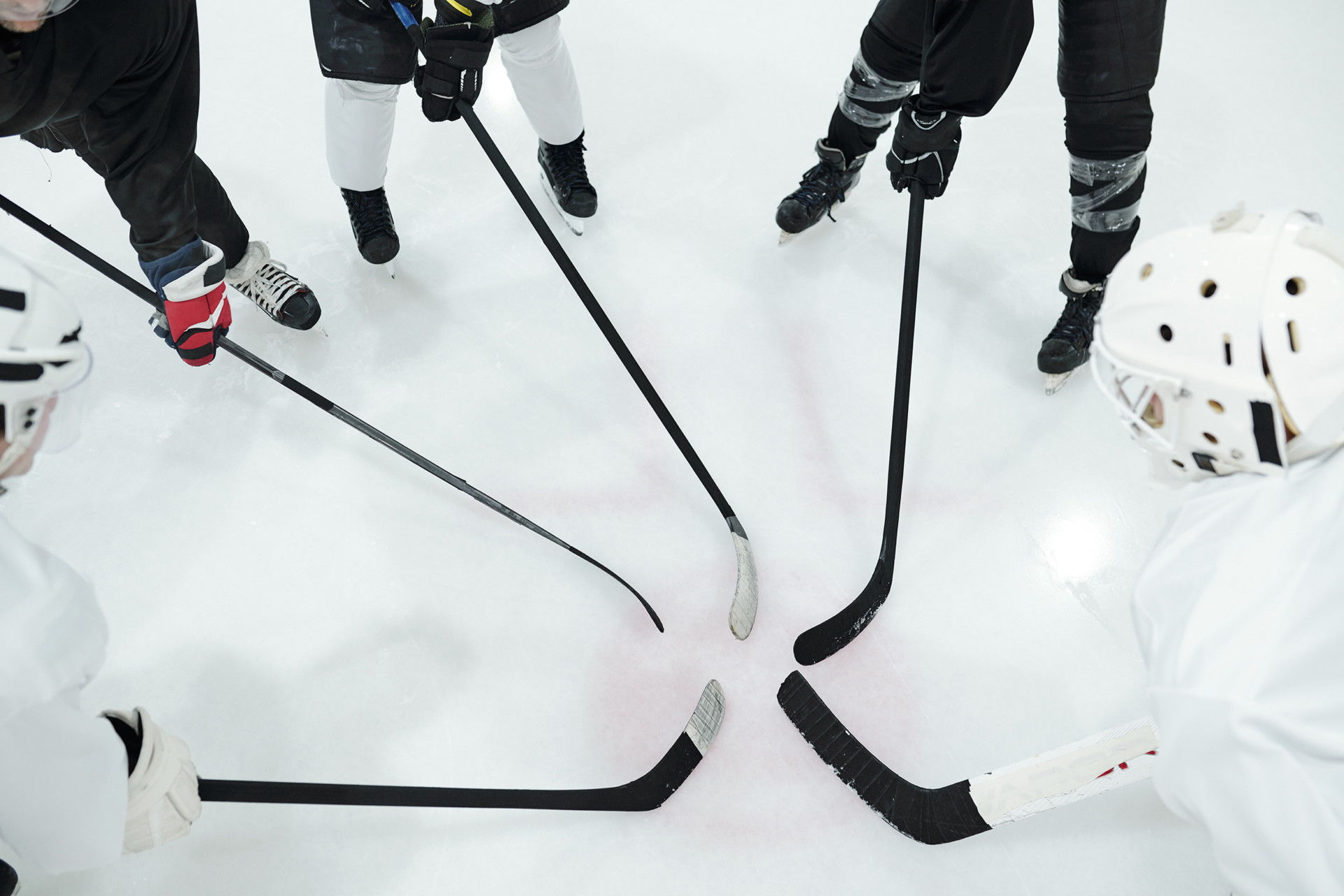 Group of hockey players in sports uniform, gloves and skates standing in circle